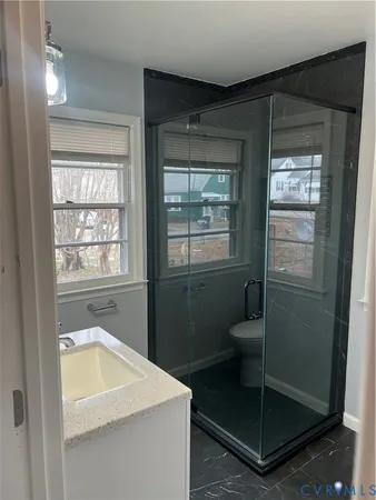 a bathroom with a shower sink and mirror