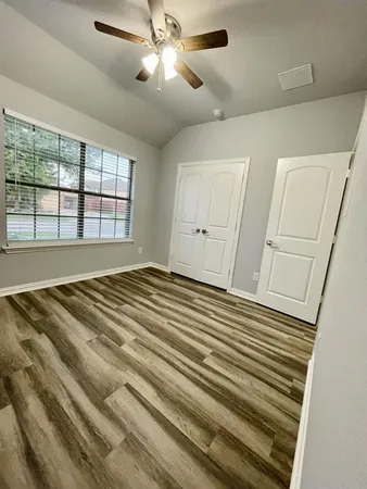 a view of a room with wooden floor and fan