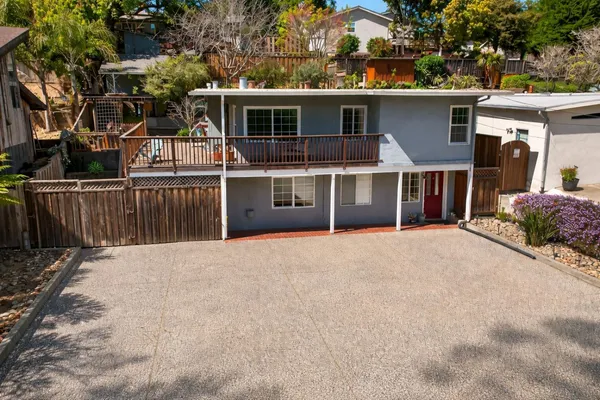 a view of a house with a yard and potted plants