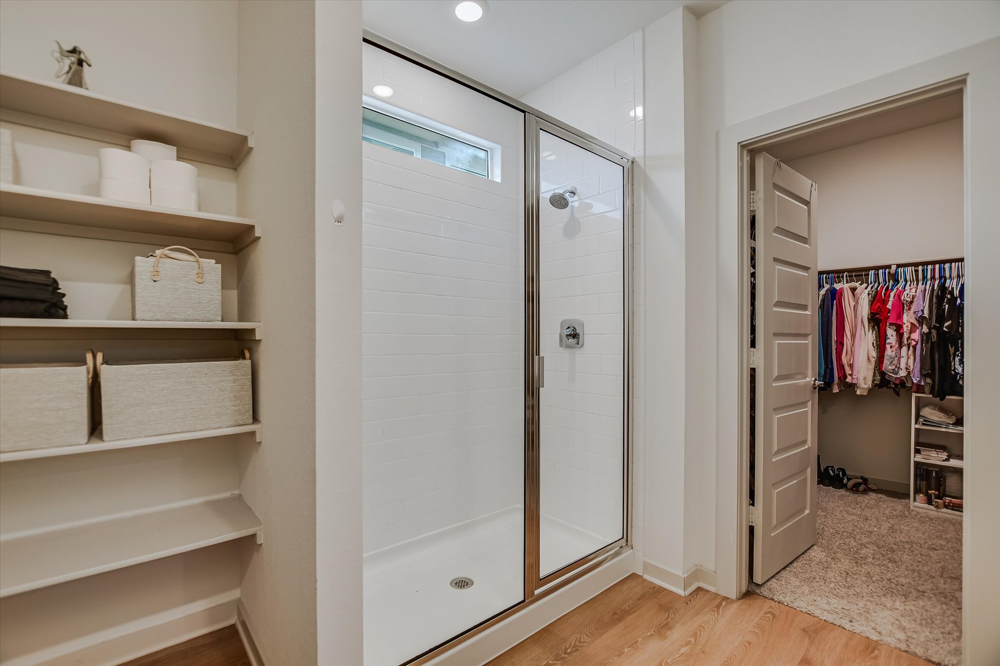 105 Merrick Road Georgetown, TX 78628 - Photo 11 of 23 A well-appointed shower with glass enclosure and transom window offers a spa-like retreat, alongside convenient built-in shelving.