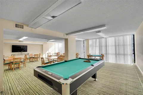 a room with pool table and windows