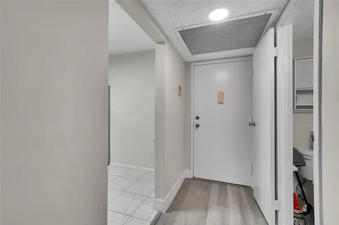a view of hallway with walk in closet and wooden floor