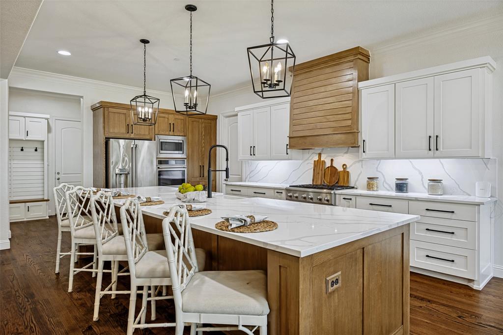 641 Maggie Trail Lucas, TX 75002 - Photo 11 of 37 a kitchen with a stove a kitchen island with a dining table and chairs