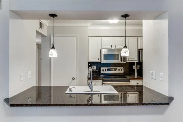 a kitchen with kitchen island a counter top space appliances and cabinets
