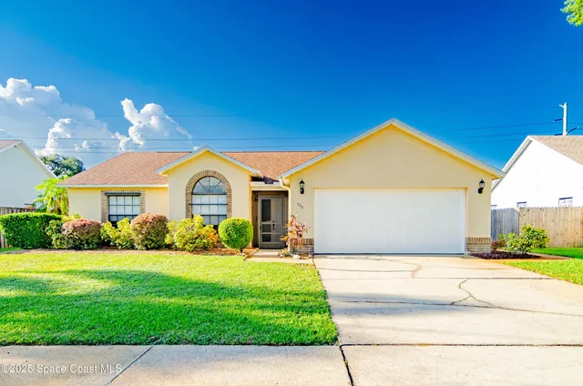 a view of a house with a big yard plants and large trees