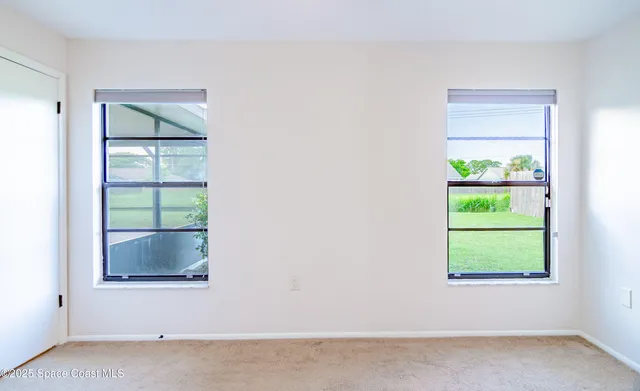 an empty room with a chandelier fan and a ceiling fan