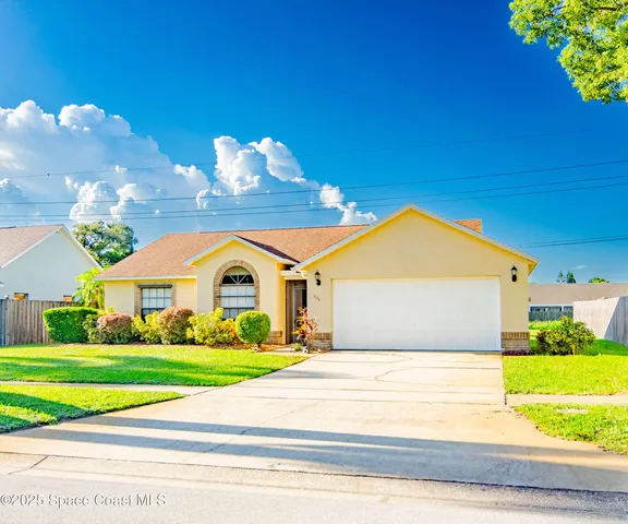 a front view of a house with a garden and yard