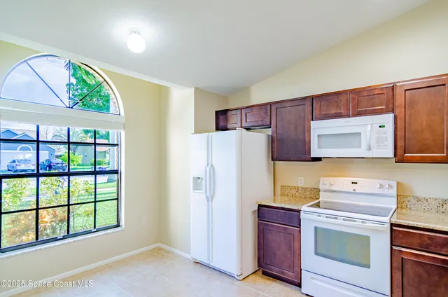 a kitchen with stainless steel appliances a stove a refrigerator and a window