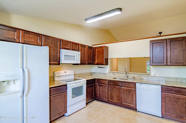 a kitchen with granite countertop a sink stainless steel appliances and cabinets