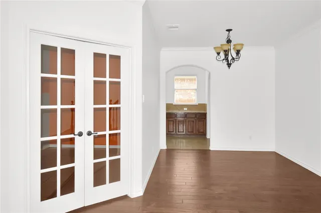 a view of a hallway with wooden floor and windows