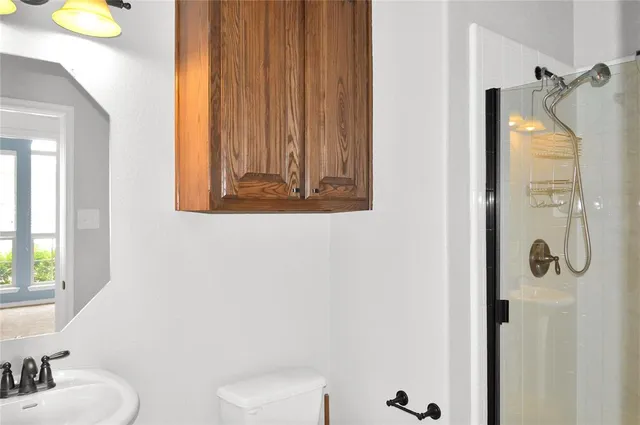 a bathroom with a sink and mirror with toilet