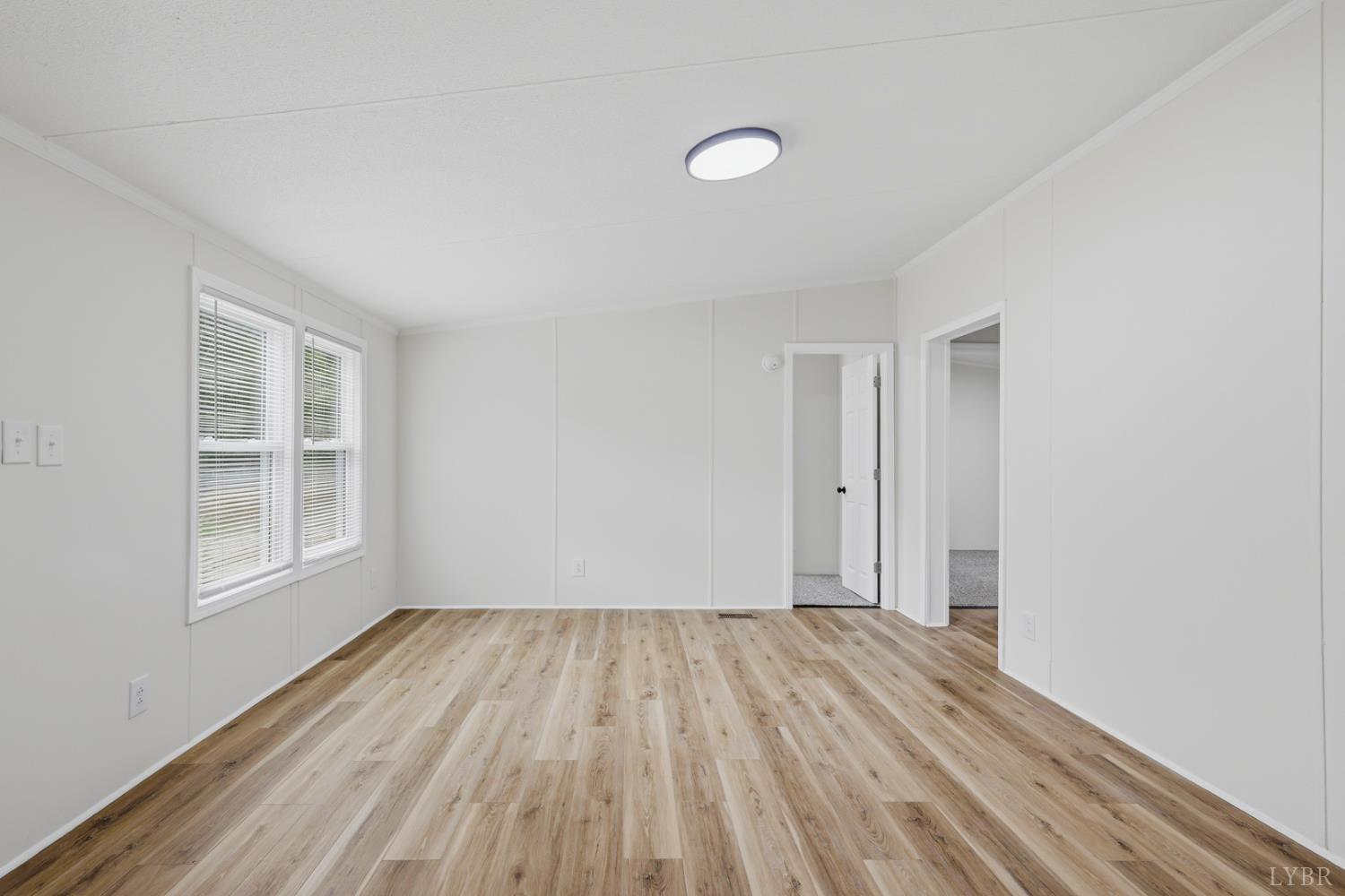 304 Ridgelake Road Goodview, VA 24095 - Photo 5 of 29 an empty room with wooden floor and windows