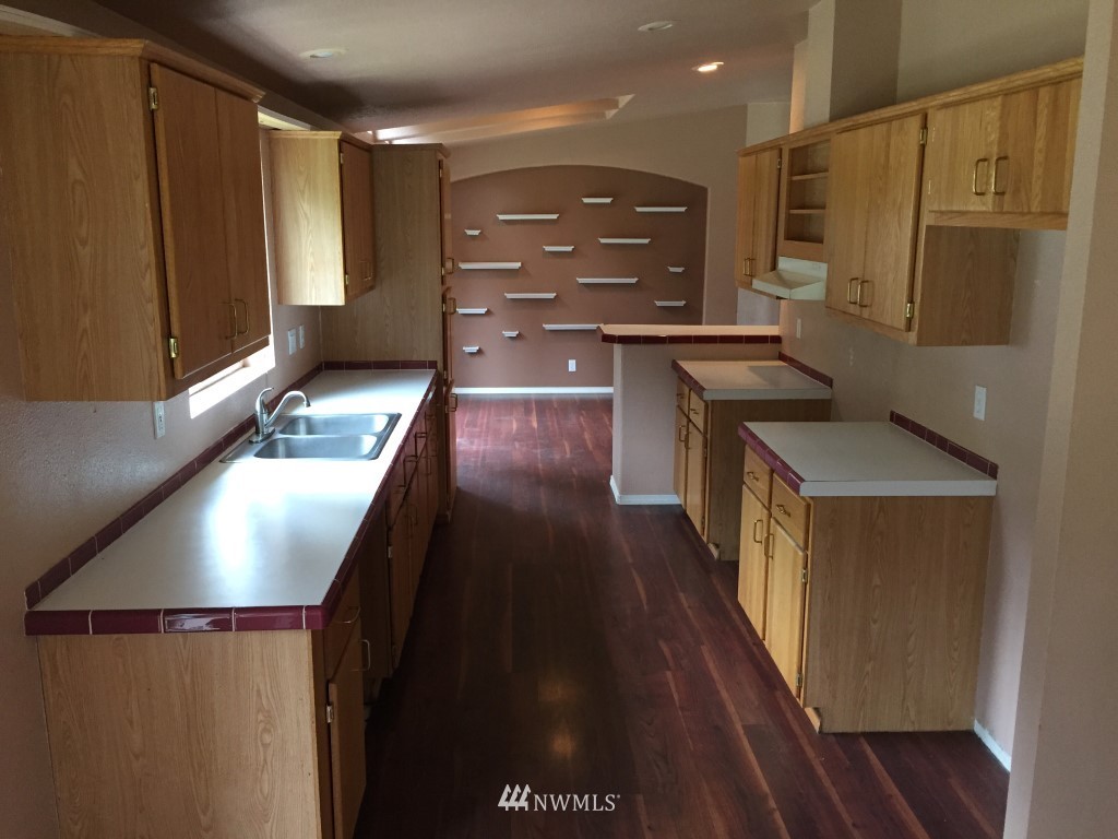 21922 Summers Road Centralia, WA 98531 - Photo 5 of 17 a kitchen with stainless steel appliances granite countertop a refrigerator a stove and a sink with wooden floor