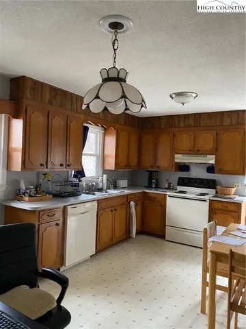 a room with lots of wooden furniture and a potted plant