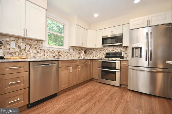 a kitchen with stainless steel appliances a refrigerator sink and microwave