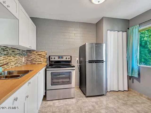 a kitchen with stainless steel appliances granite countertop a refrigerator and a sink