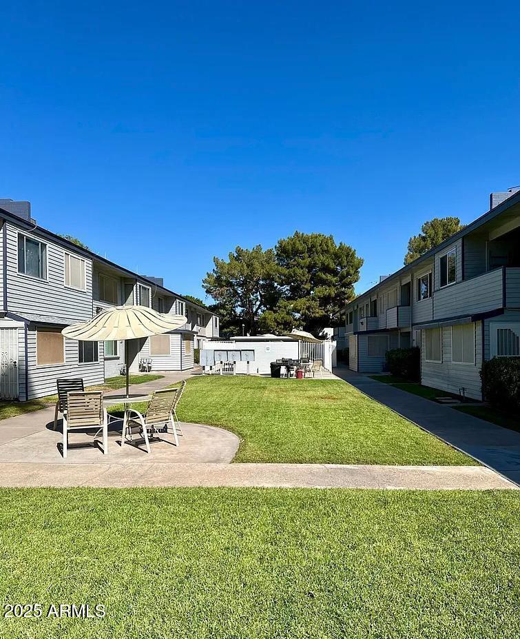 2551 West Rose Lane, Unit 222 Phoenix, AZ 85017 - Photo 10 of 12 a swimming pool with outdoor seating and yard