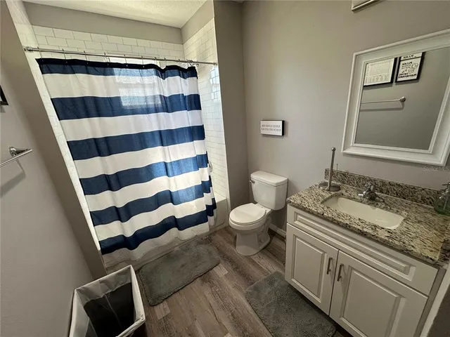 a bathroom with a granite countertop toilet a sink and a mirror
