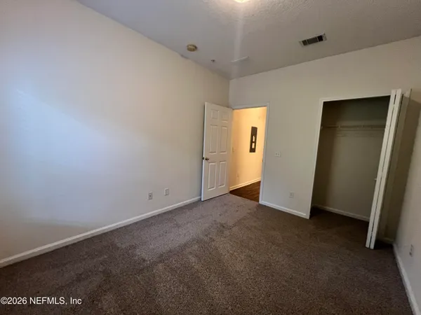 an empty room with closet and mirror