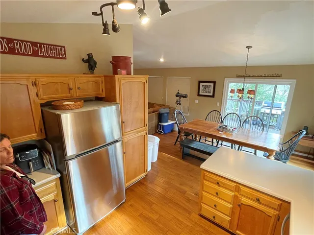 a kitchen with stainless steel appliances refrigerator stove and wooden floor