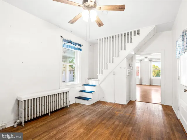 a view of staircase with wooden floor and fan