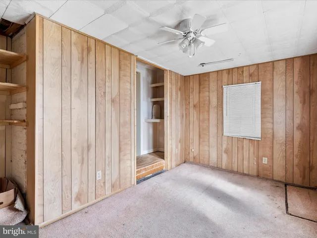 a view of a livingroom with a ceiling fan & entryway