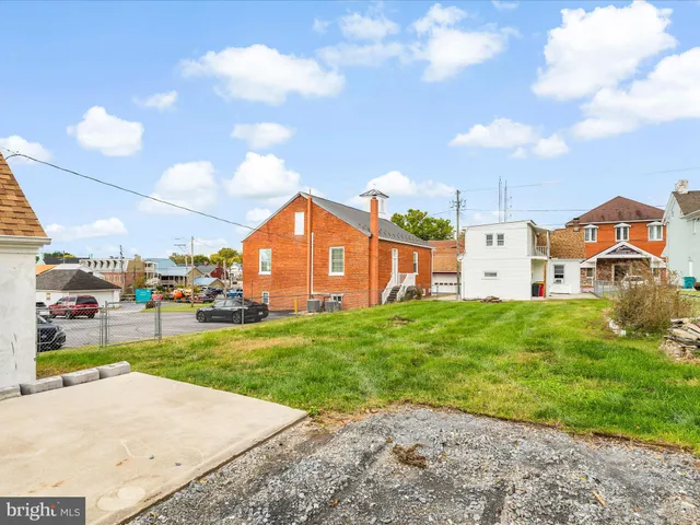 a view of a big house with a big yard and potted plants