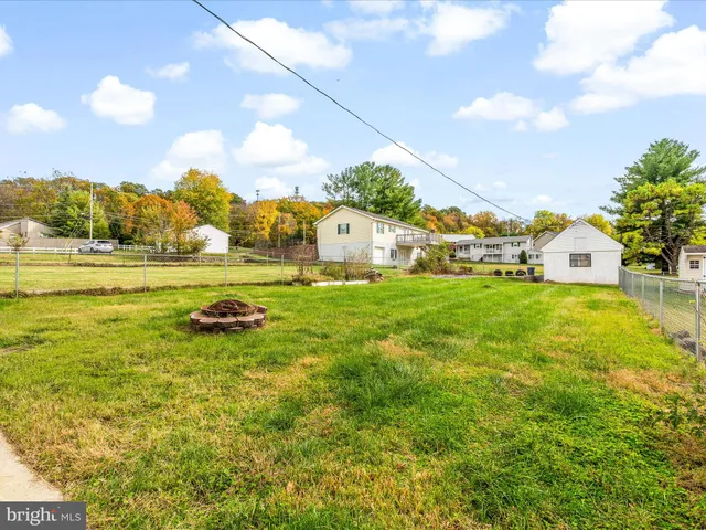 a view of yard with swimming pool and trees in the background
