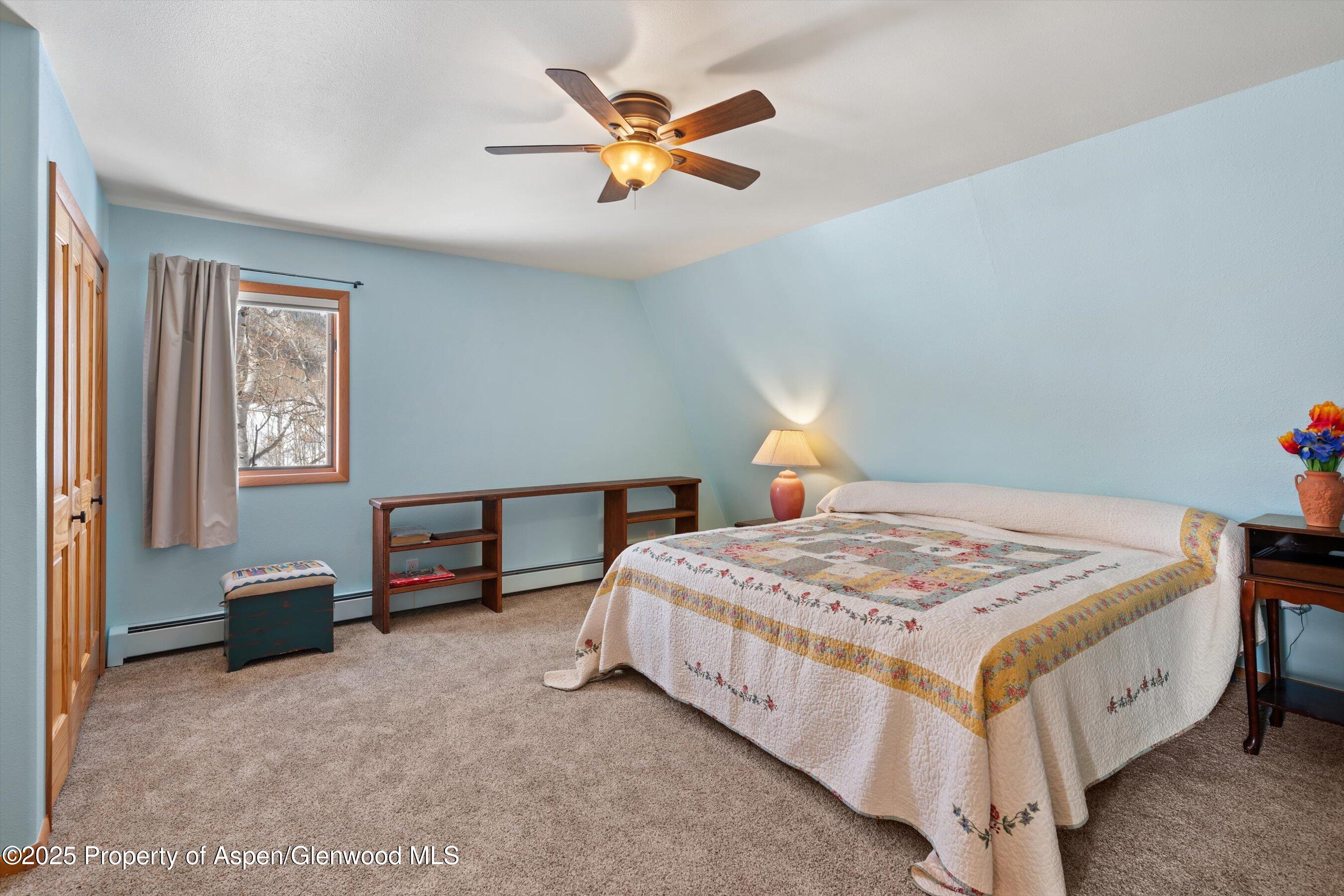 238 Hawk Lane Basalt, CO 81621 - Photo 30 of 46 a bedroom with a bed and a chandelier