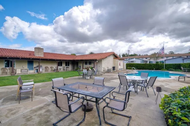 a view of a swimming pool with a table and chairs in patio