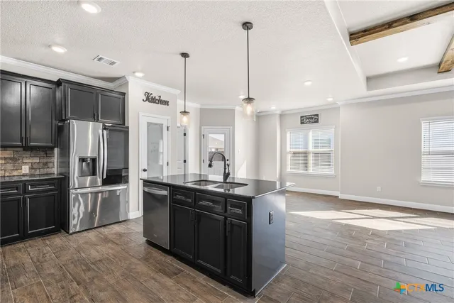 a kitchen with stainless steel appliances granite countertop a sink a stove and a refrigerator