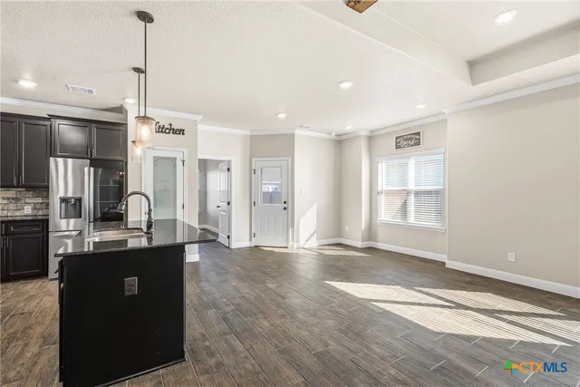 a kitchen with stainless steel appliances granite countertop a sink a stove and a refrigerator