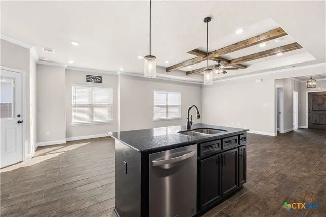 a kitchen with stainless steel appliances granite countertop a sink a stove and a wooden floors