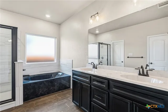 a bathroom with double vanity and a mirror
