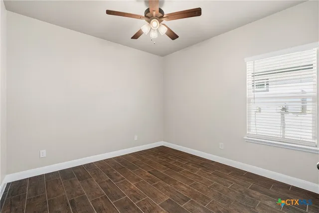 wooden floor in an empty room with a window