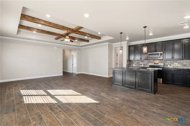 a kitchen with stainless steel appliances granite countertop a stove a sink and a refrigerator