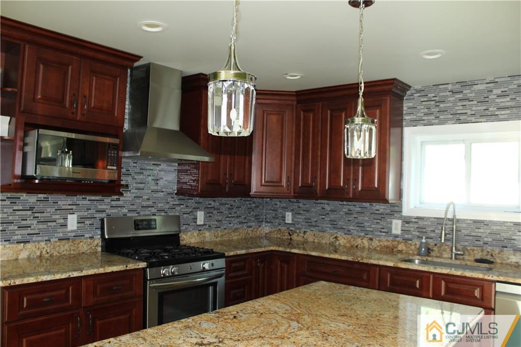 15 Kenmore Road Edison, NJ 08817 - Photo 12 of 35 a kitchen with stainless steel appliances granite countertop wooden cabinets a stove a sink and a granite counter tops