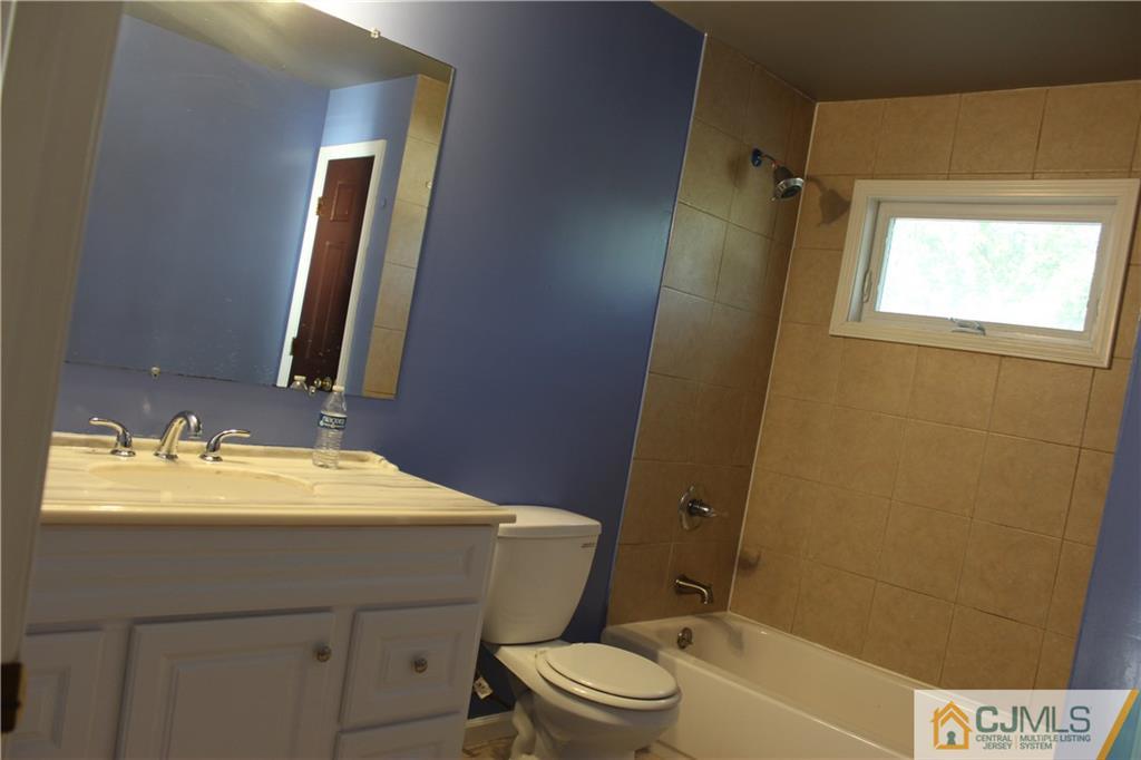 15 Kenmore Road Edison, NJ 08817 - Photo 19 of 35 a bathroom with a sink a toilet and shower