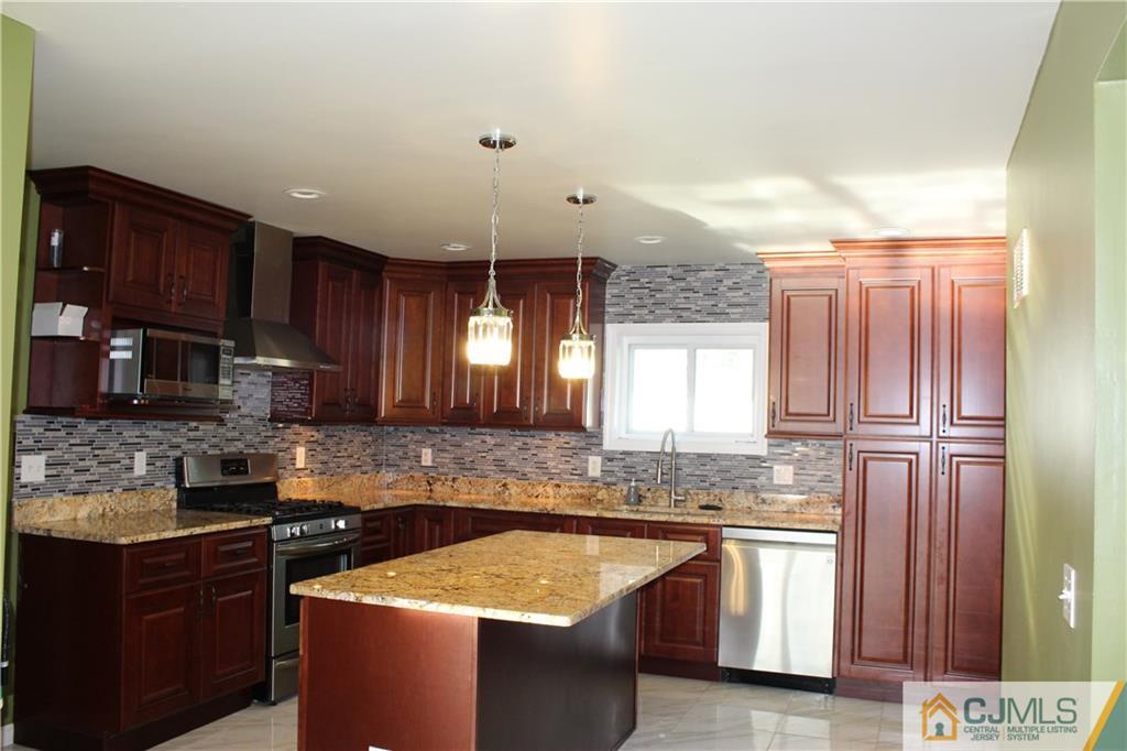 15 Kenmore Road Edison, NJ 08817 - Photo 7 of 35 a kitchen with stainless steel appliances granite countertop wooden cabinets a refrigerator and a sink