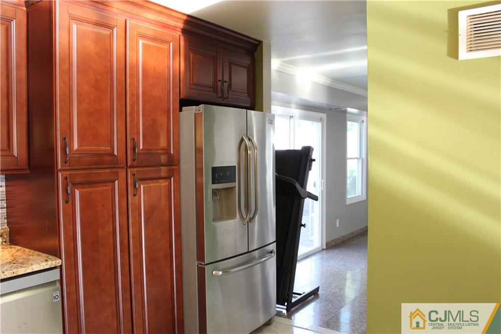 15 Kenmore Road Edison, NJ 08817 - Photo 9 of 35 a metallic refrigerator freezer sitting in a kitchen