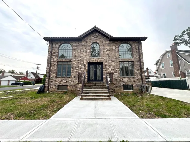 a front view of a house with a garden