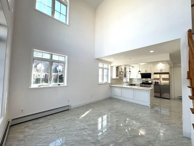 a large white kitchen with cabinets
