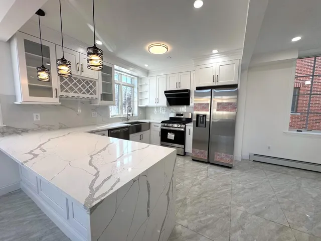 a kitchen with stainless steel appliances a refrigerator and a stove top oven