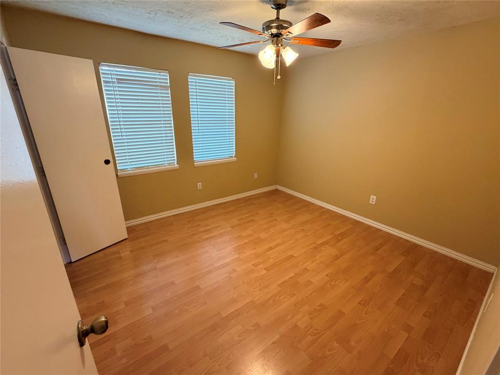 2051 Embassy Way Carrollton, TX 75006 - Photo 17 of 20 Unfurnished room with light wood finished floors, ceiling fan, and a textured ceiling