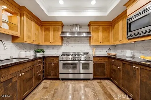 a kitchen with stainless steel appliances granite countertop a refrigerator and a sink