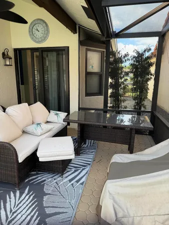 a living room with couches bookshelf and a large window