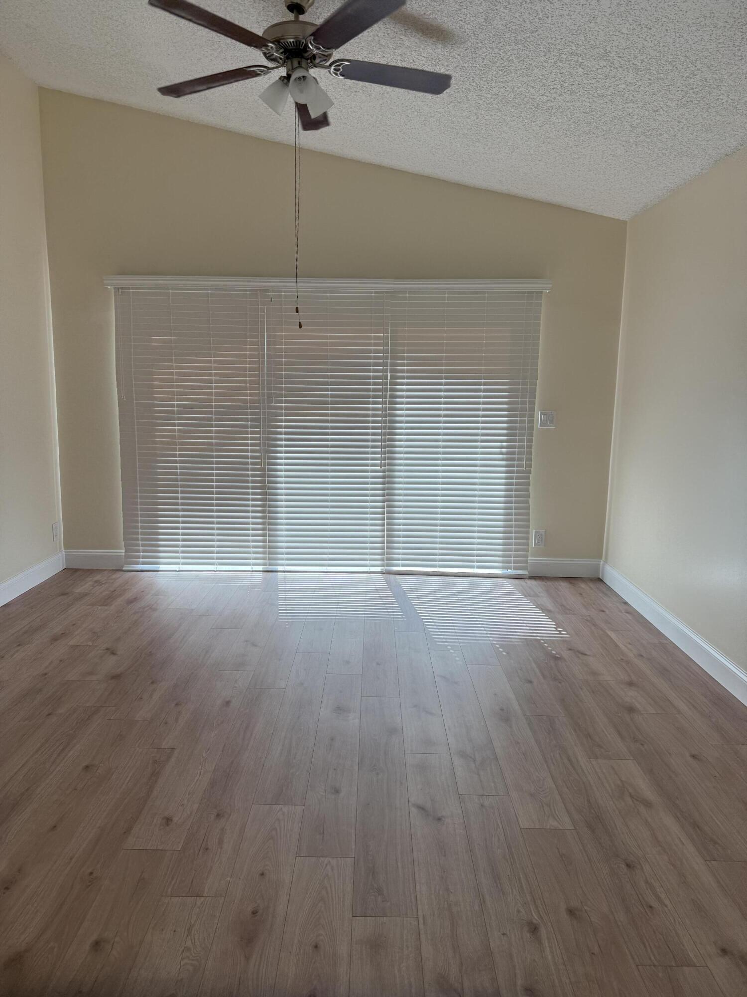 21583 Villa Nova Drive Boca Raton, FL 33433 - Photo 19 of 33 an empty room with wooden floor and fan