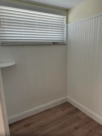 a view of a small space with wooden floor and a window