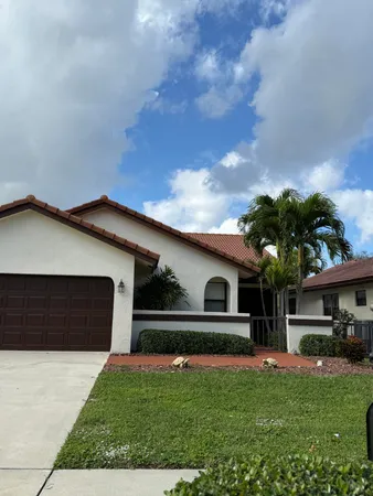 a front view of a house with a garden and yard