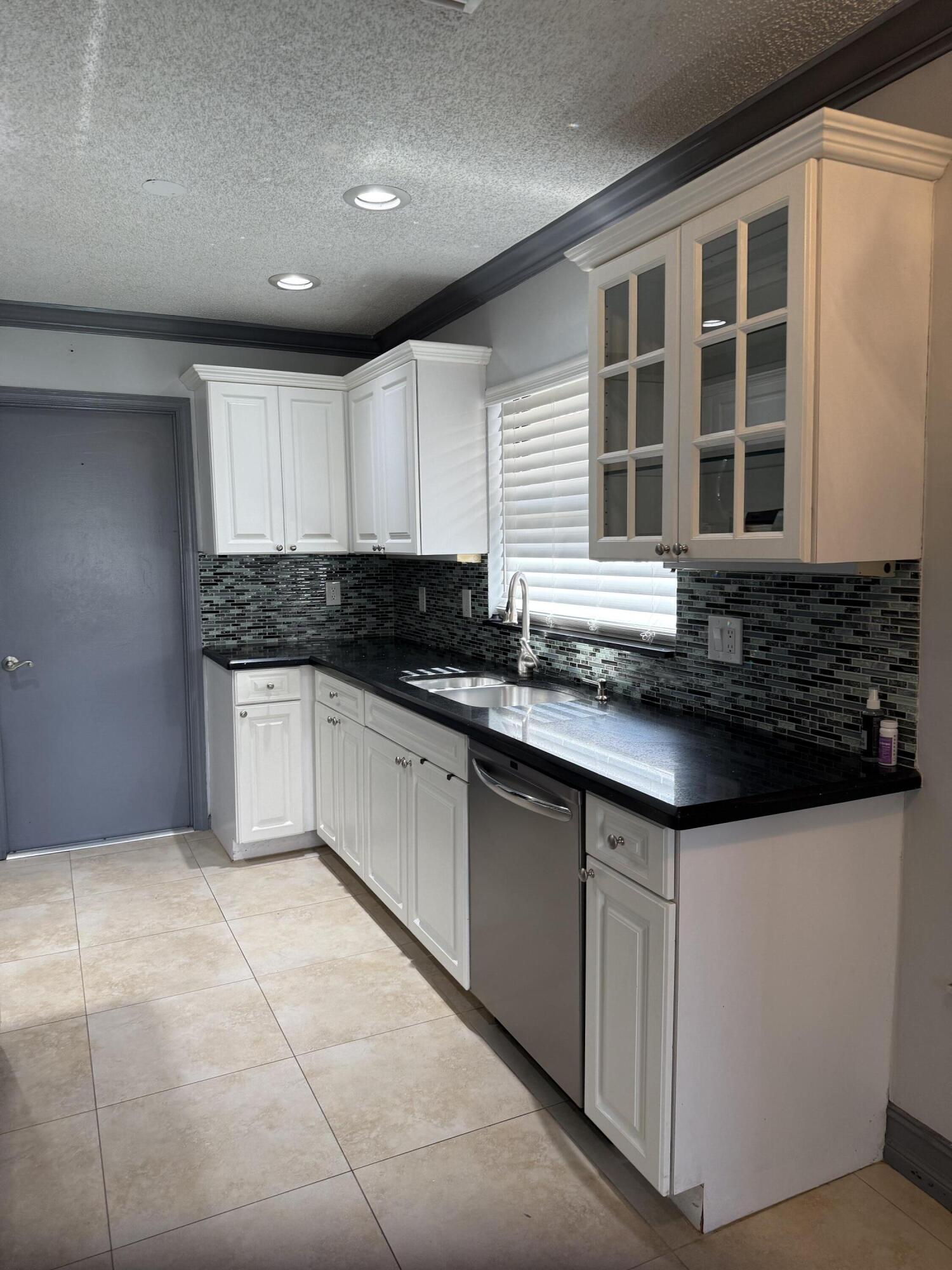 21583 Villa Nova Drive Boca Raton, FL 33433 - Photo 7 of 33 a kitchen with granite countertop a sink and white cabinets